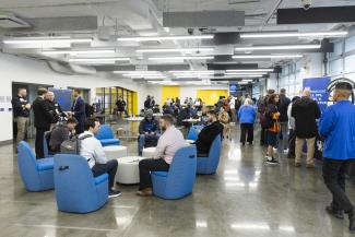 Overview image of the Cornerstone building in the middle of cybercon, all of the attendees are seen walking around a networking.