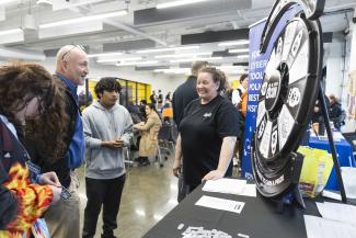 Cybersecurity Analyst, Jackie Campbell is seen hosting the Cybersecurity trivia wheel with attendees.