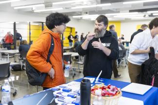 Marc Bradley talking with a student attendee.